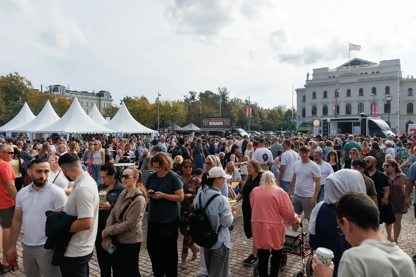 A crowd between white festival tents and food trucks on a square in central Gothenburg