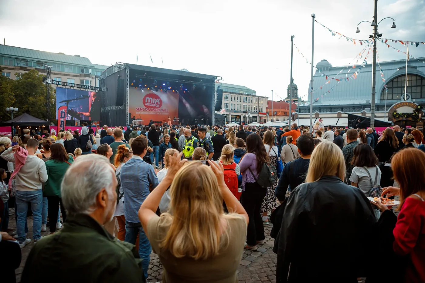 The crowd in front of the main stage with a big screen at Göteborgs Kulturkalas 2023, central Gothenburg buildings behind