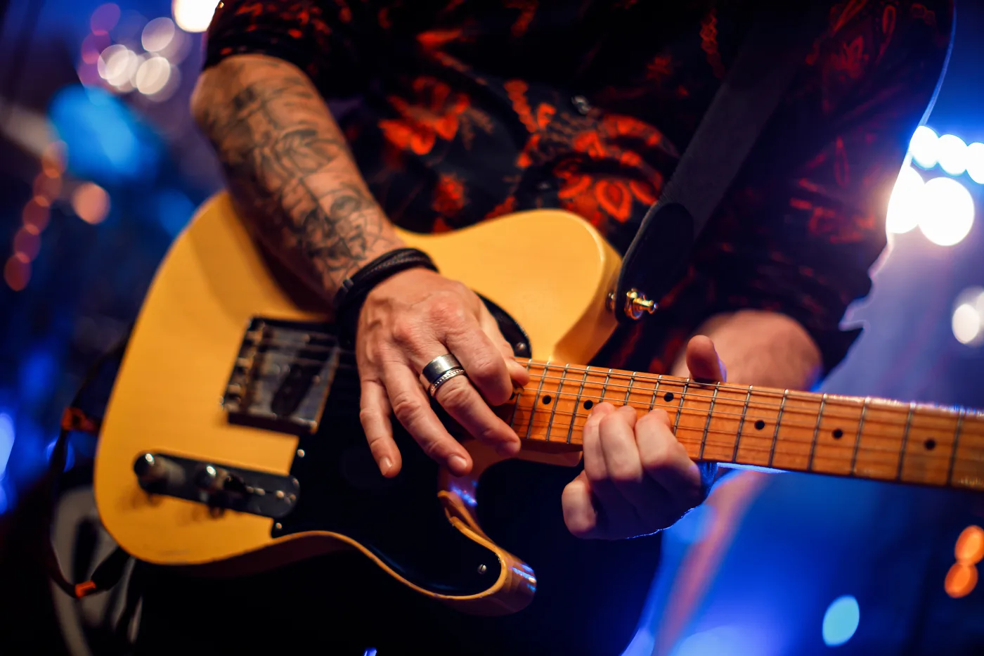 A guitarist’s hands on a yellow electric guitar, rock concert at Lindholmen Street Food Market, Gothenburg