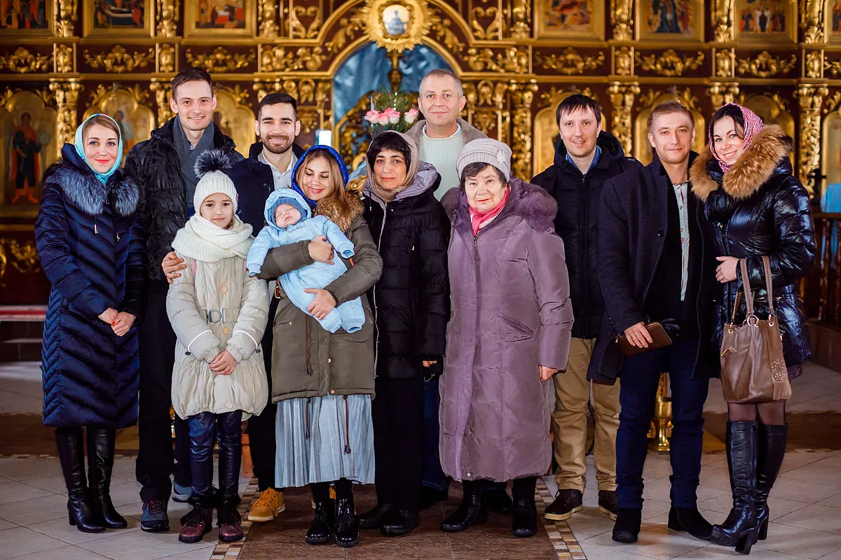 Parents, godparents and relatives with the baby by the iconostasis