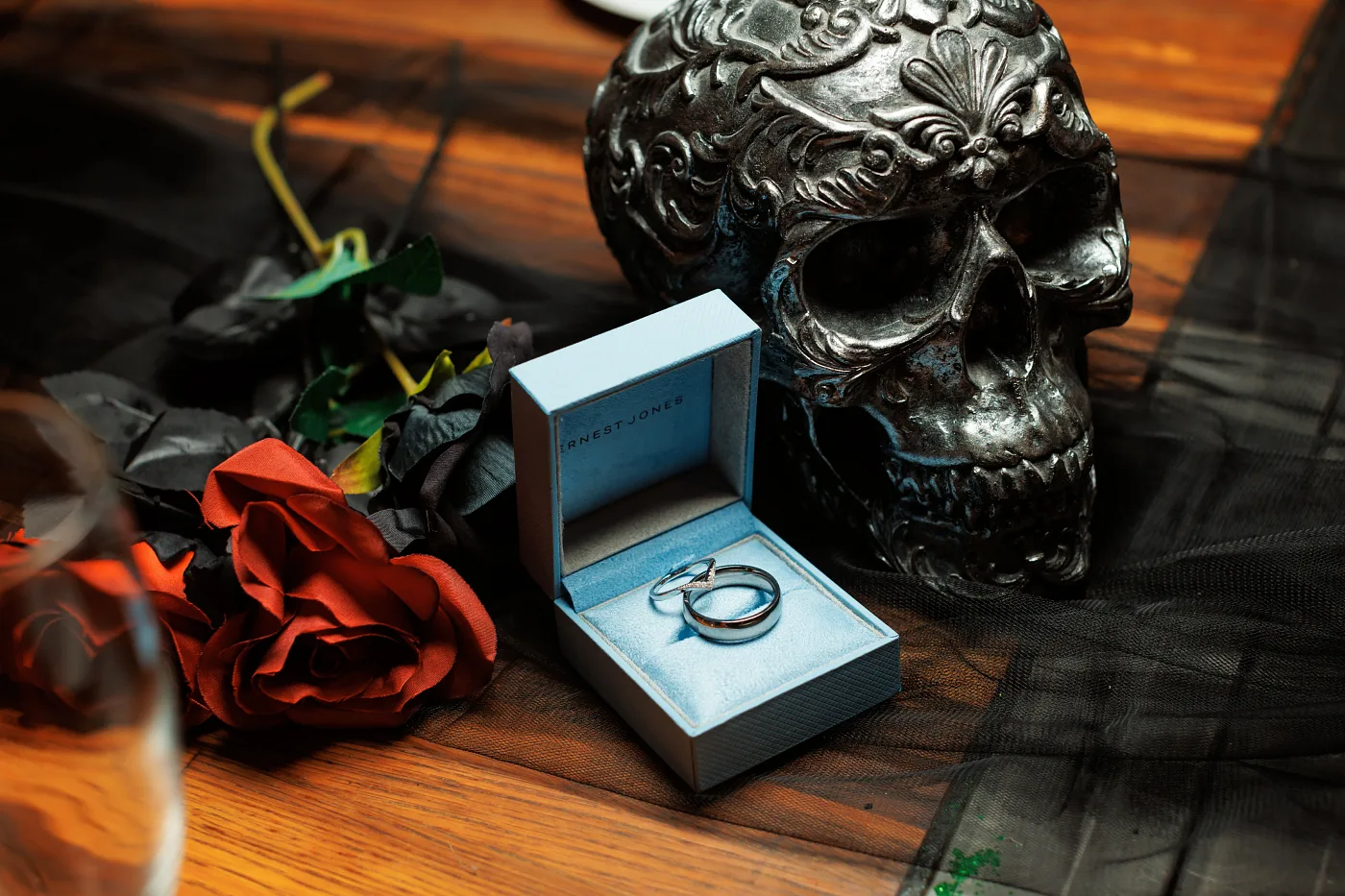 A ring in an open box among the evening decor: black tulle and red roses