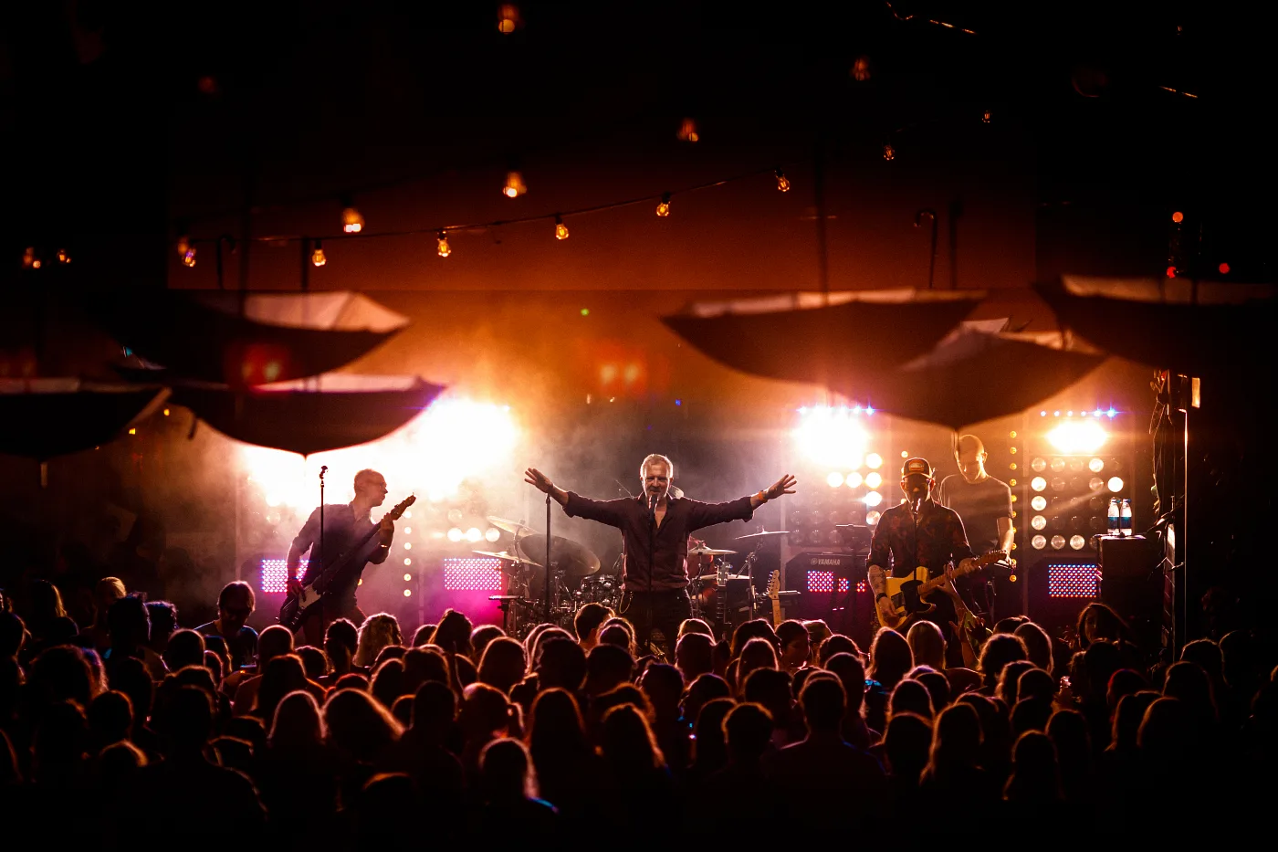 The singer and the band on stage with the crowd packed in front