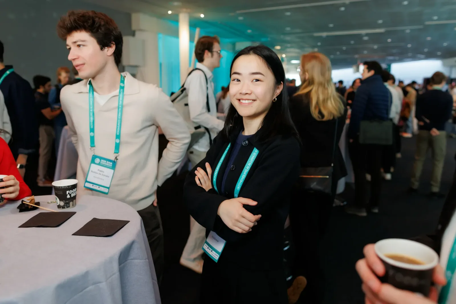 Two conference attendees with name badges smiling at a table in the break