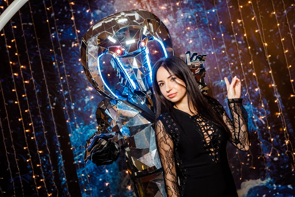 Woman posing next to a performer in an LED robot costume