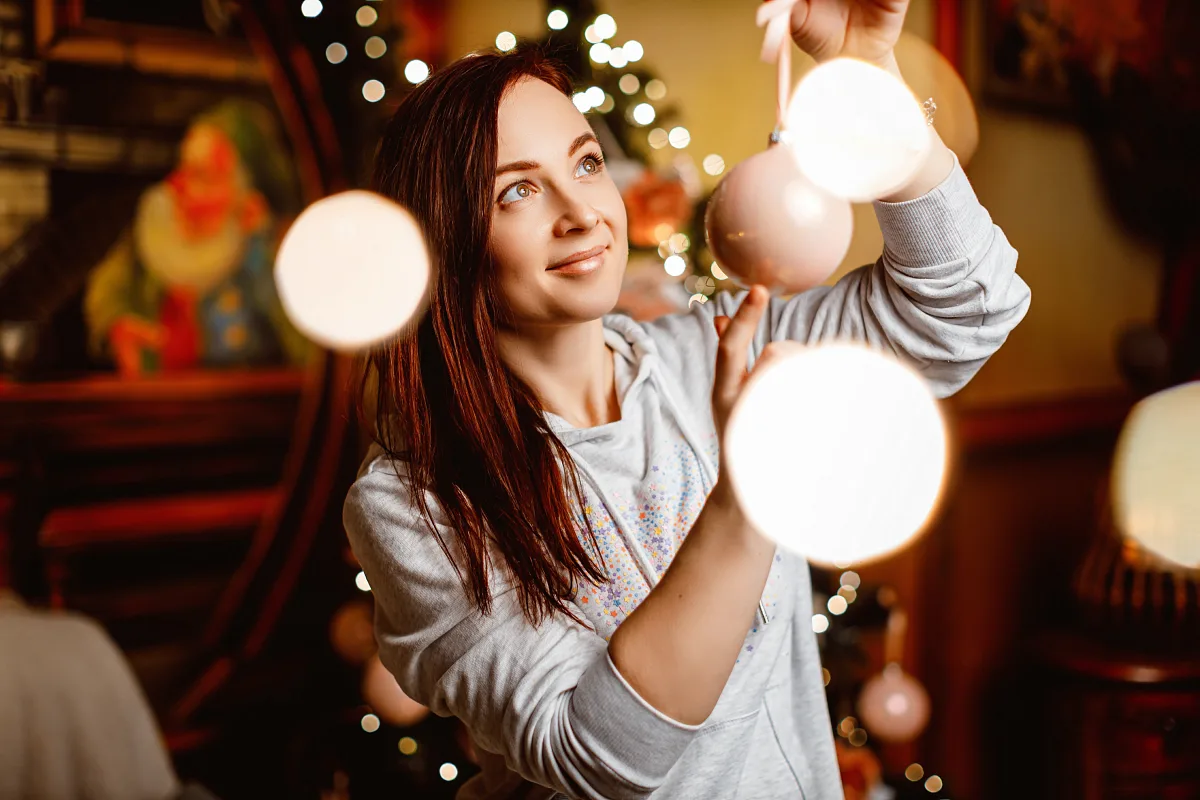 Woman among string lights with warm bulbs