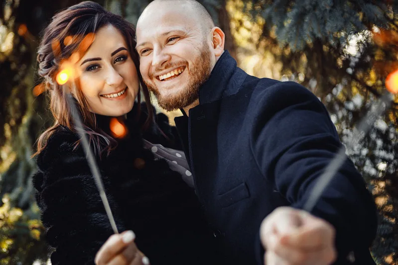 Couple with sparklers embracing in an autumn park