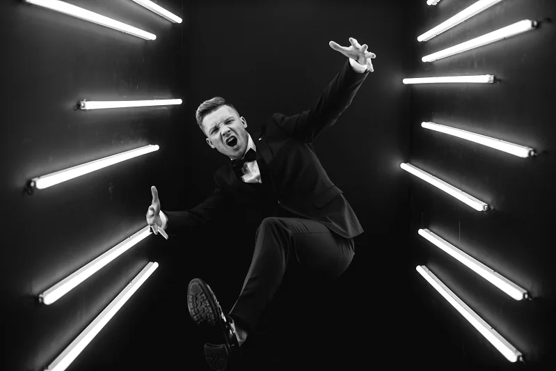 Man in a suit among neon tubes, black and white frame
