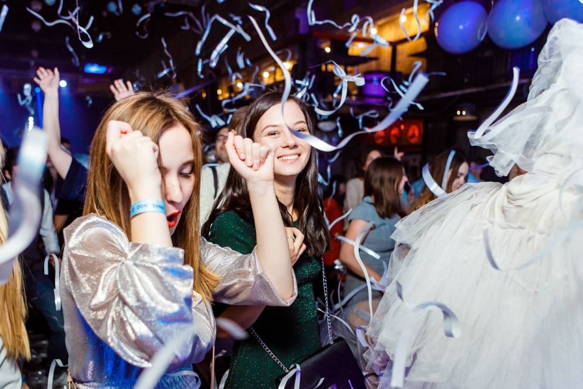 Event photography capturing professional moments during a conference, including speakers and attendees under bright lights