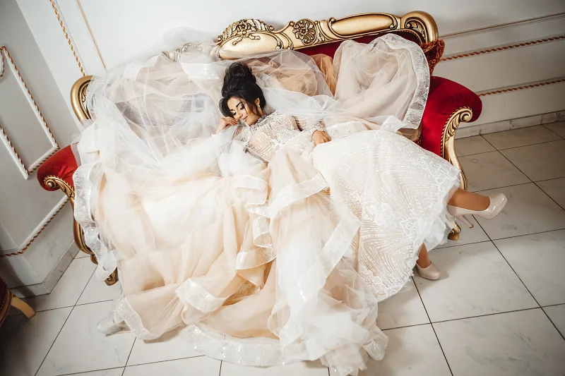 Bride resting in her dress on a velvet sofa